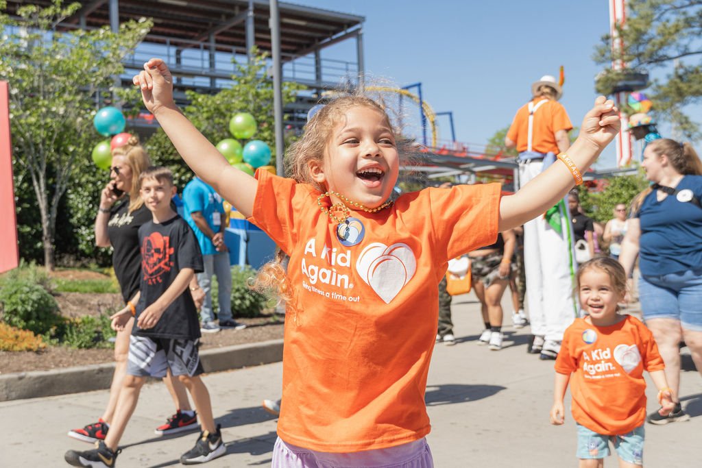 Girl smiling and cheering with her hands in the air.